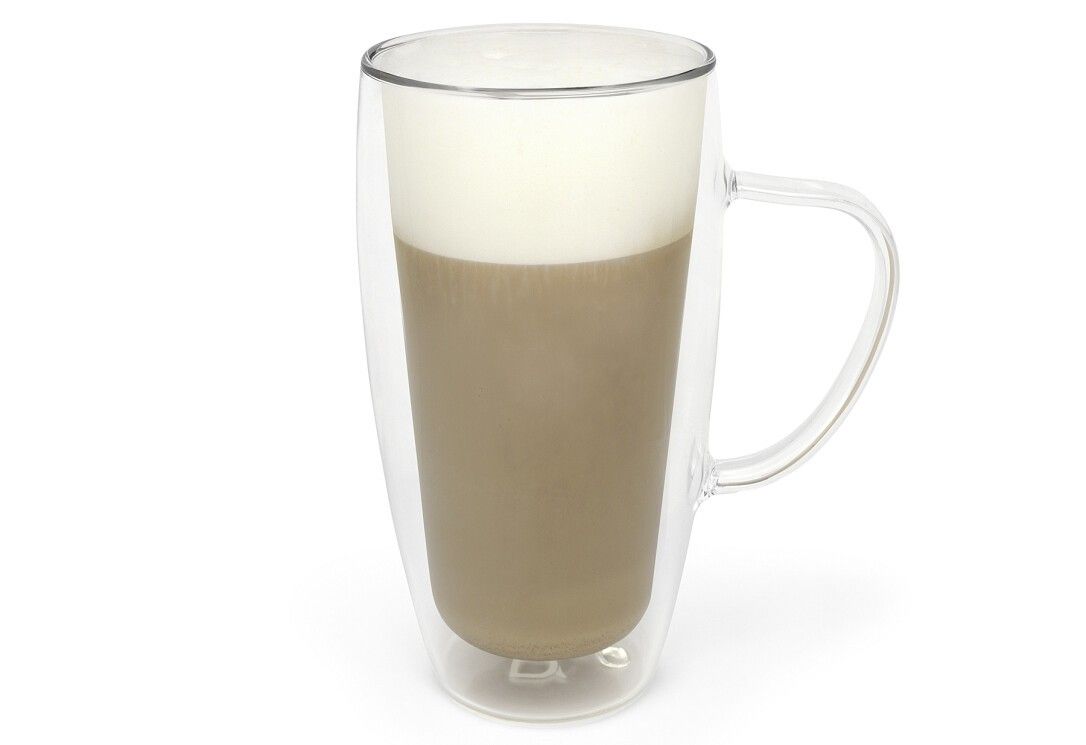 Un bicchiere trasparente per latte macchiato con manico, riempito con caffè a strati e schiuma di latte.