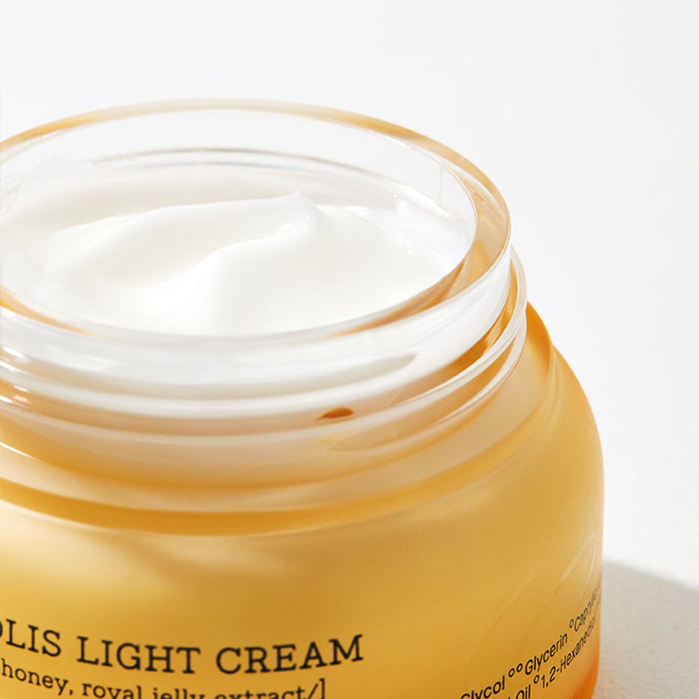 Primo piano della COSRX Propolis Light Cream in un barattolo di vetro.