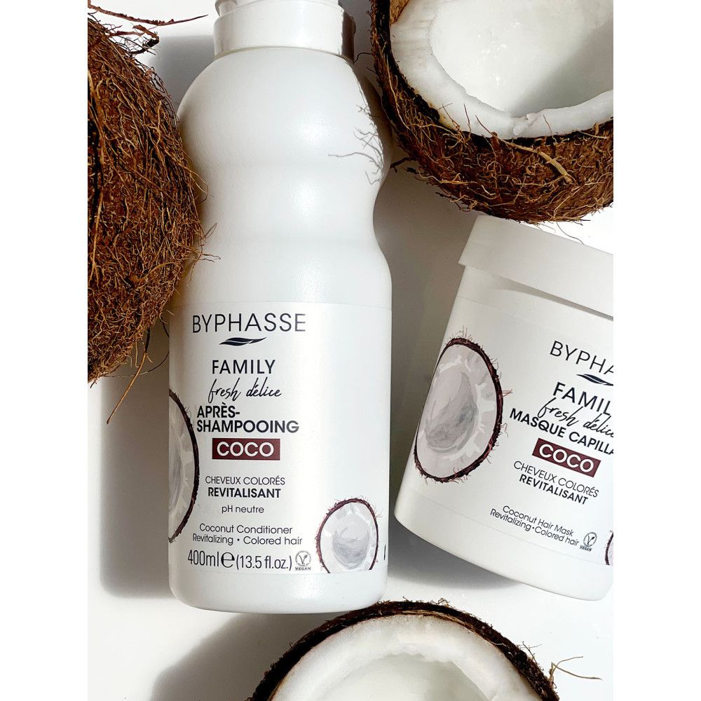 Bottiglia e vaso bianchi. Scritta: Byphasse, Family Fresh Délice, Coco. Sfondo di cocco.