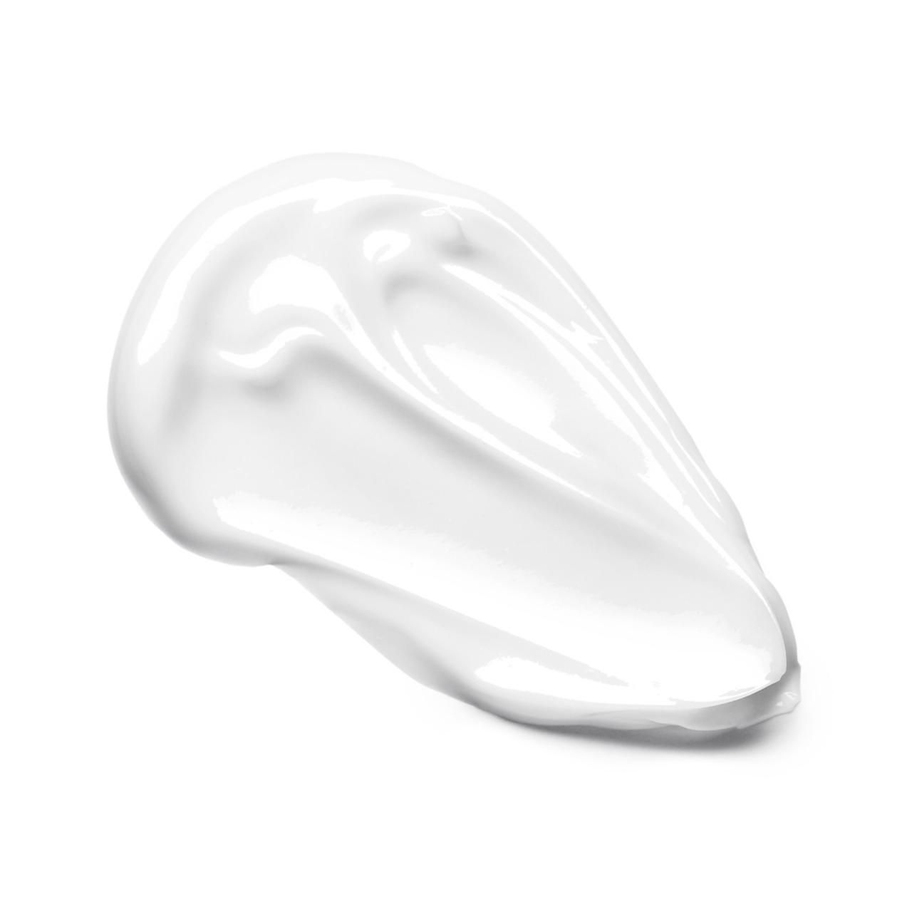 Macchia di crema bianca. Texture liscia, leggermente lucida. Su sfondo bianco.