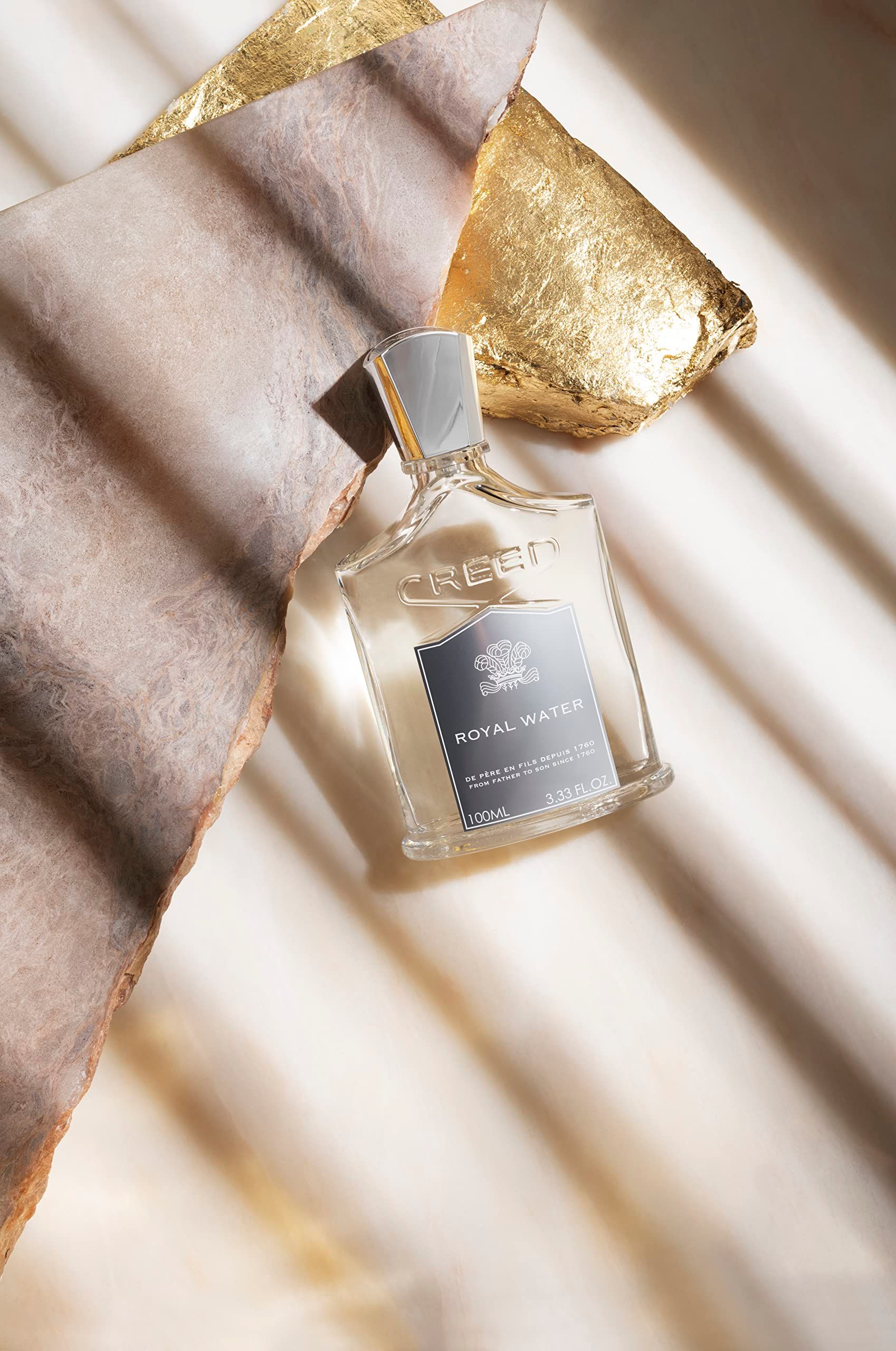 Flacone su marmo con foglia d'oro. Etichetta "CREED ROYAL WATER".