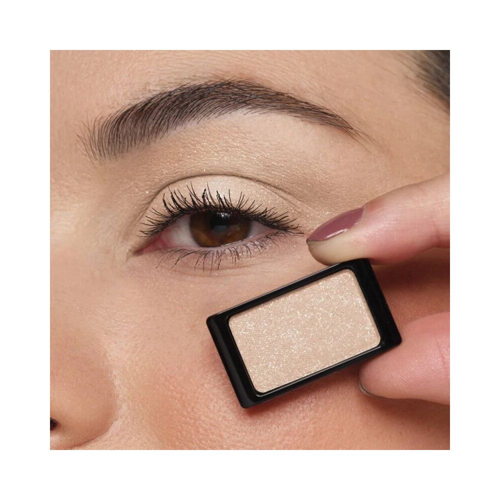 Occhio con ombretto. Un ombretto beige rettangolare è tenuto davanti all'occhio. Cornice nera.