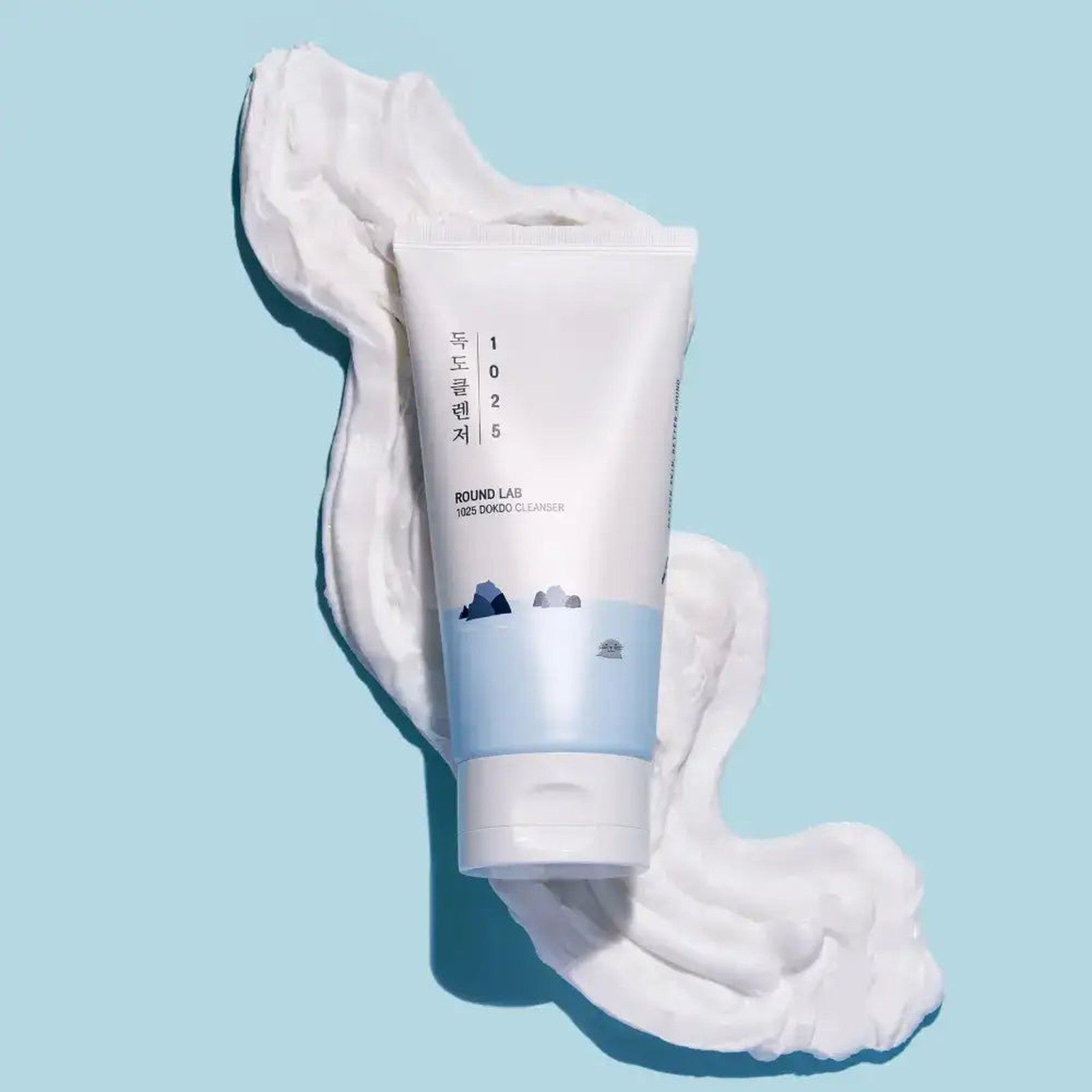 Tubo bianco con fascia blu e schiuma su sfondo blu.