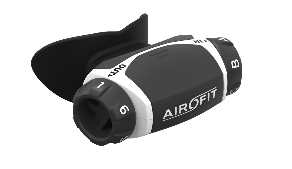 Airofit Aktiv, allenatore respiratorio. Dispositivo bianco e nero con boccaglio e manopole. Scritte: Airofit, OUT, 1-6, A-B.