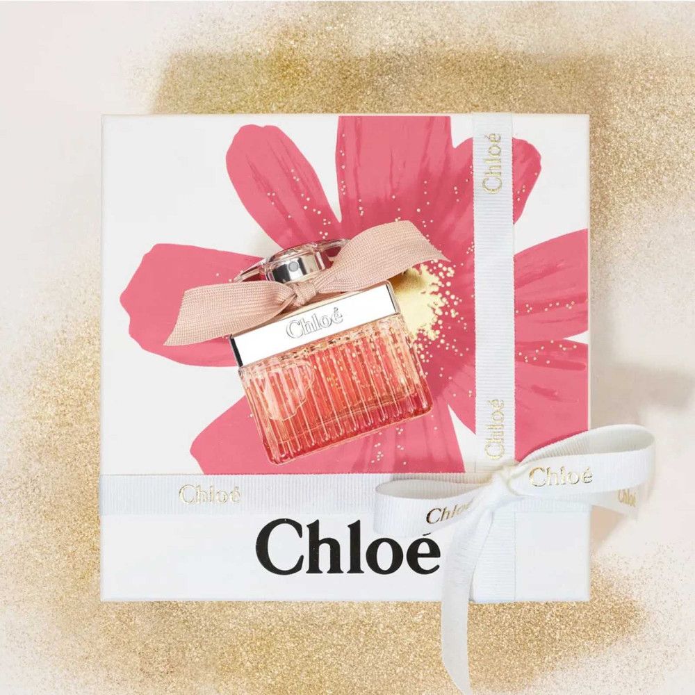 Confezione regalo con fiore rosa e fiocco. Flacone con fiocco. Scritta Chloé su scatola e fiocco.