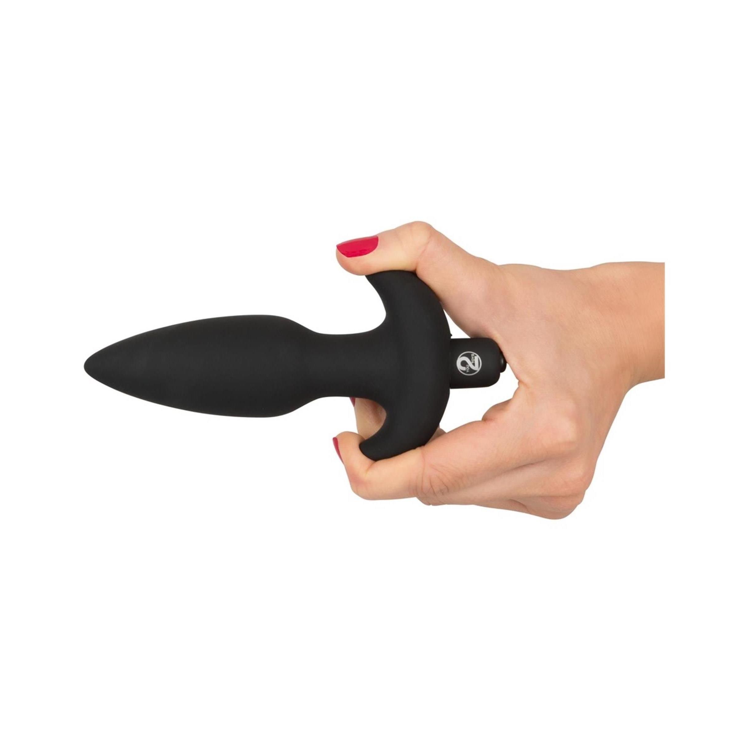 Mano che tiene un plug nero. Conico, con impugnatura a T. Smalto rosso.