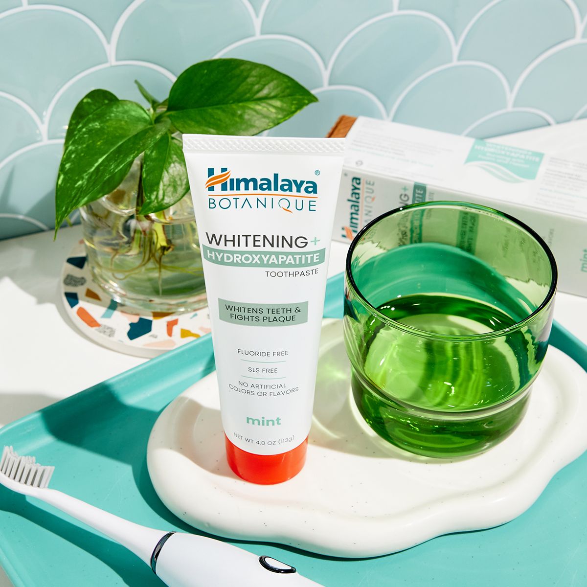 Dentifricio Himalaya Botanique Whitening su un vassoio con bicchiere e spazzolino.