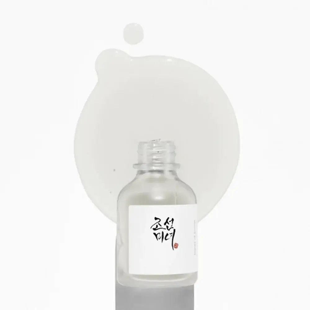 Flacone di vetro con siero e goccia. Scritta: Beauty of Joseon. Sfondo bianco.
