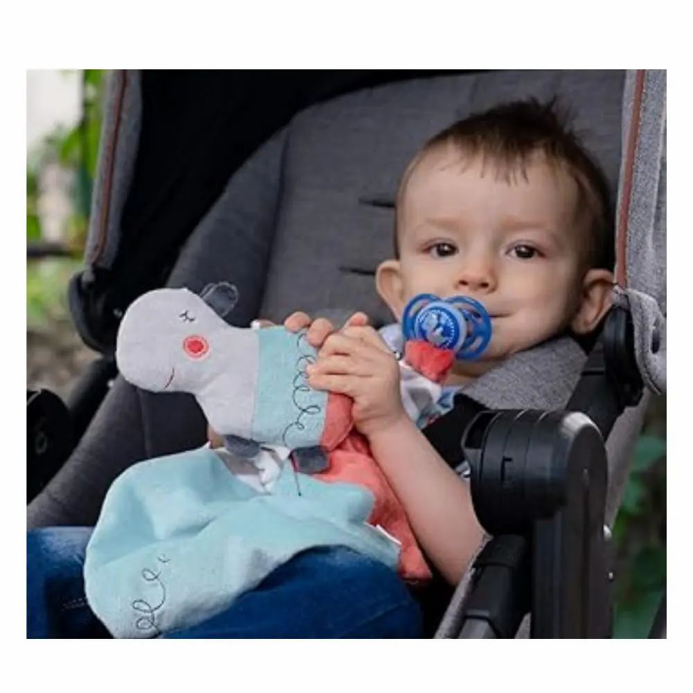 Bambino in passeggino con doudou e ciuccio. Testa di ippopotamo, tessuto blu.