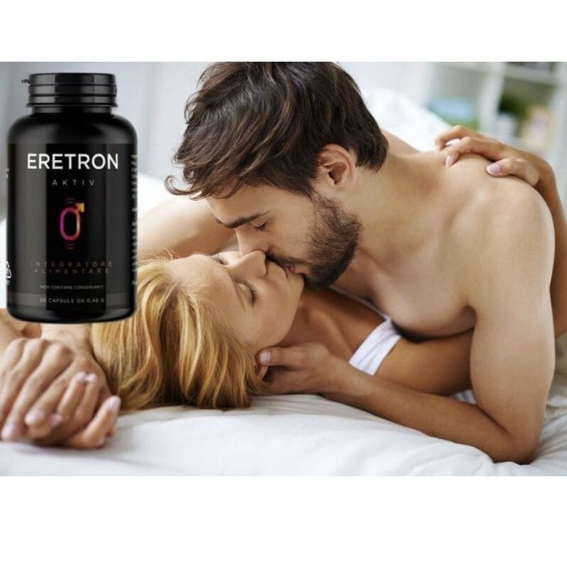 Coppia che si bacia a letto. Accanto, un flacone "Eretron Aktiv". Flacone nero con simbolo maschile. "Integratore Alimentare".
