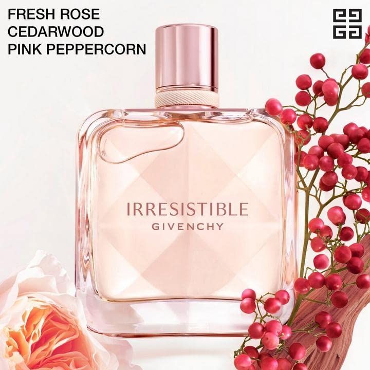 Flacone in vetro con contenuto rosa. Scritta "IRRESISTIBLE GIVENCHY". Decorazione con pepe rosa, rosa e legno.