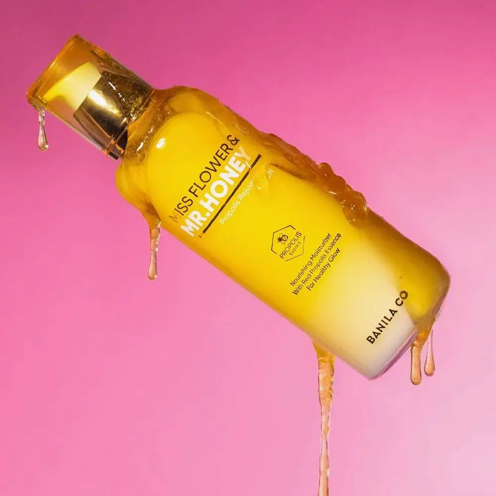 Lozione giallo-bianca con pompa dorata, ricoperta di miele. Scritta: MISS FLOWER & MR. HONEY. Scritta: BANILA CO.
