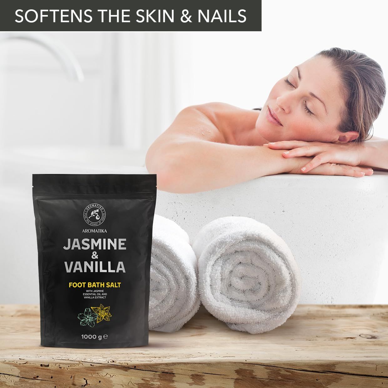 Donna in vasca da bagno con asciugamani. Accanto a lei, una confezione nera con il nome del prodotto Jasmin & Vanille. 1000 g.