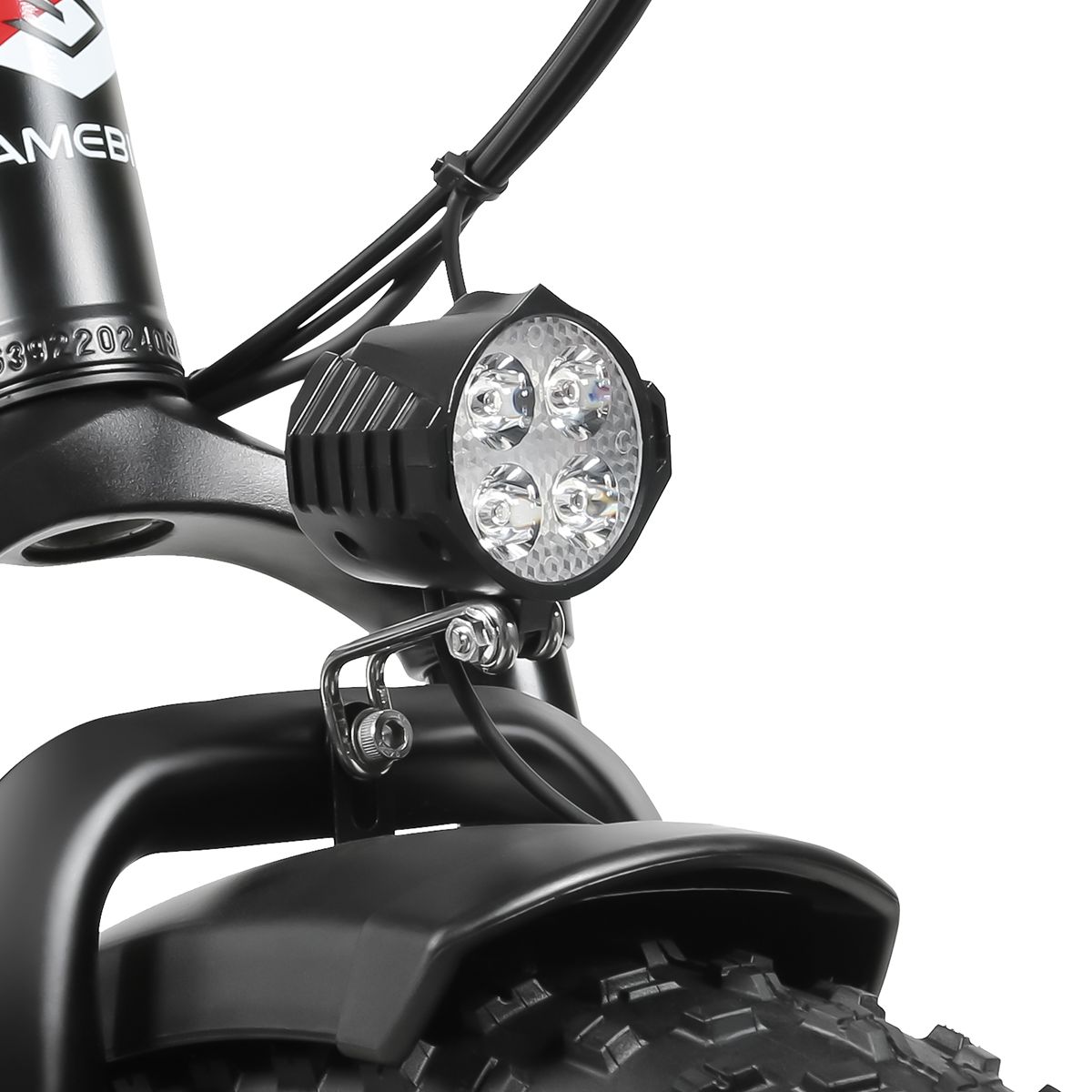 Primo piano del faro di una bicicletta elettrica. Quattro luci a LED visibili. Alloggiamento nero e parafango.