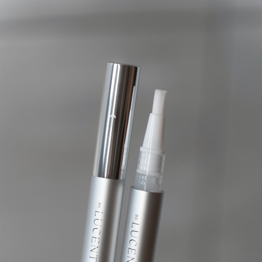 Penna argentata con punta bianca. Scritta "LUCENT" sulla penna.