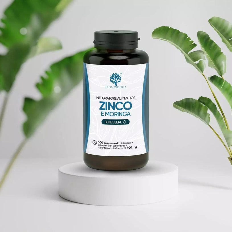 Flacone marrone, tappo nero su piedistallo. Etichetta: ZINCO E MORINGA, 300 Compresse Vegane. Logo: albero con foglie.