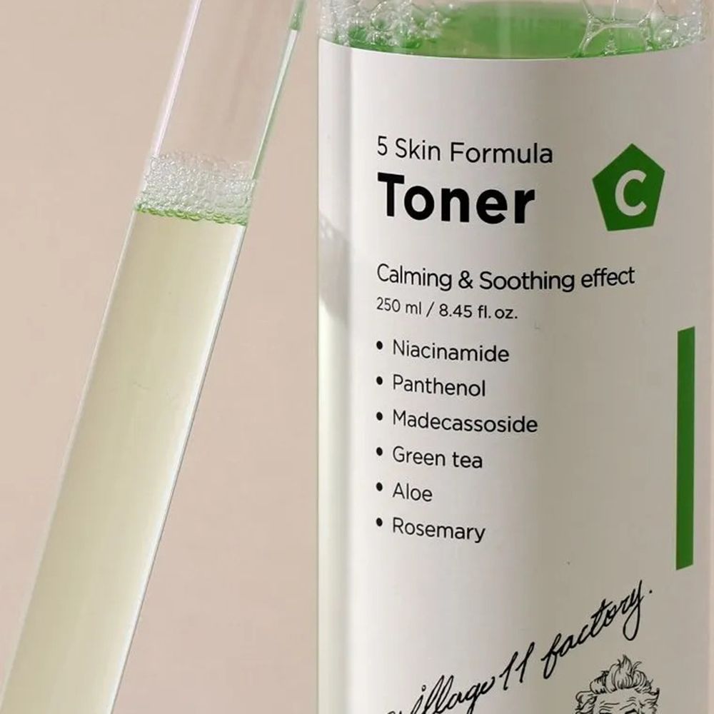 Primo piano di un flacone di liquido verdognolo e una provetta. Nome del prodotto e ingredienti sull'etichetta.