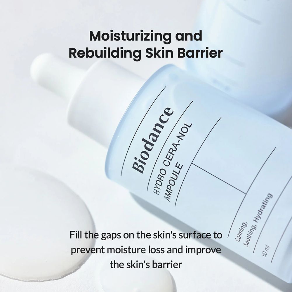 Flacone con tappo e pipetta bianchi. Scritta: Biodance, HYDRO CERA-NOL, AMPULE. Testo: Moisturizing and Rebuilding Skin Barrier. Ambiente luminoso.
