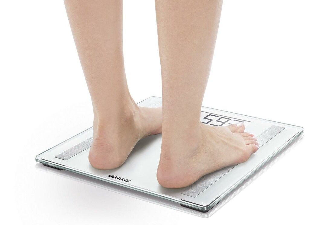Piedi su una bilancia. Il display digitale mostra 59,3. Soehnle.