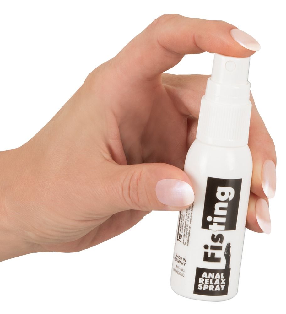 Flacone spray bianco con etichetta nera che riporta 'Fisting ANAL RELAX SPRAY'. Mano che tiene il flacone.