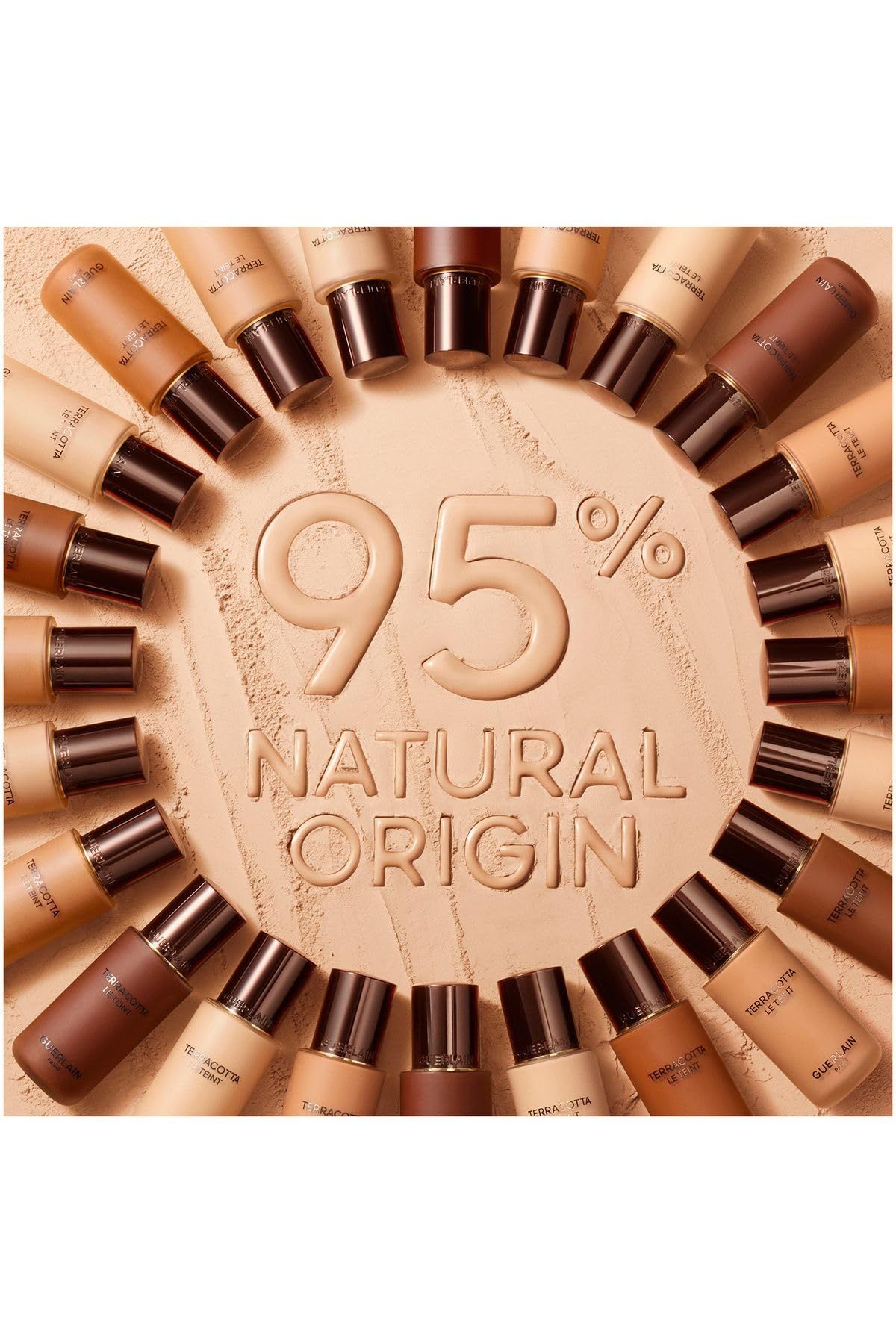 Diverse bottiglie di fondotinta Guerlain Terracotta Le Teint. Testo 95% Natural Origin. Bottiglie disposte a cerchio.