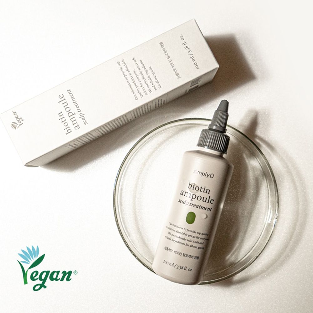 Flacone e confezione. Scritta: Biotin Ampoule Scalp Treatment. Logo Vegan. Flacone in una ciotola di vetro.
