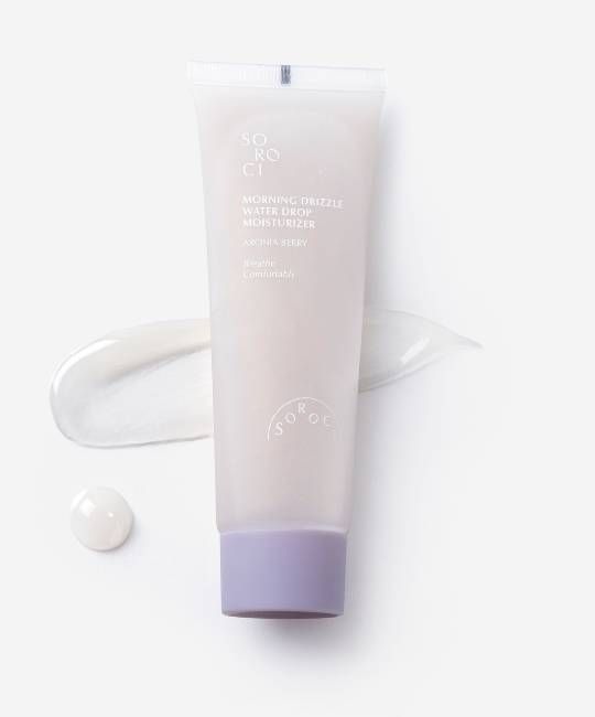 Tubo crema grigio chiaro con testo. Nome prodotto: Morning Drizzle Waterdrop Moisturizer. Marchio: Soroci. Tappo lilla. Goccia di crema.