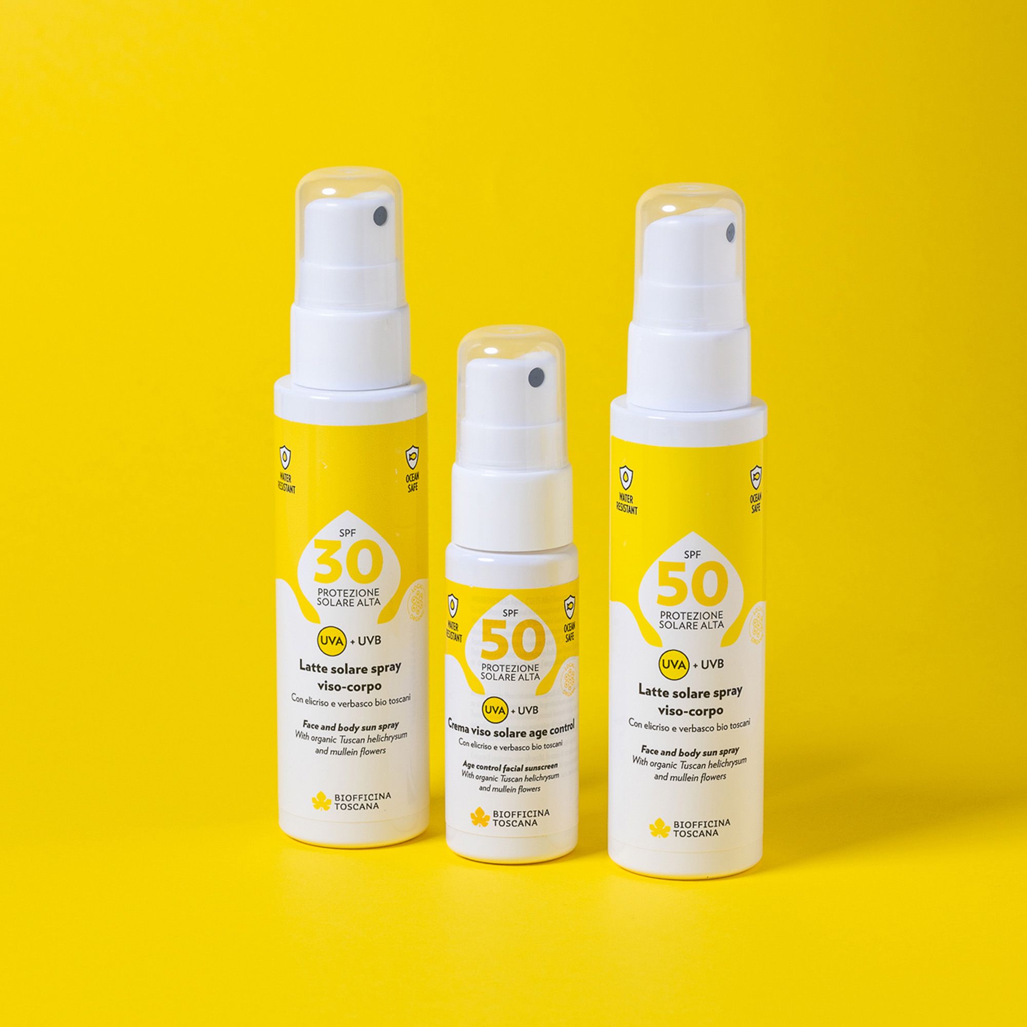Tre flaconi spray bianchi con etichette gialle. Testo: SPF 30, SPF 50, protezione solare, UVA+UVB. Marchio: Biofficina Toscana. Su sfondo giallo.