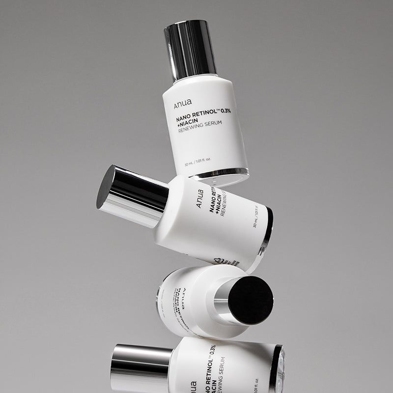 Quattro flaconi bianchi con tappi argentati. Scritta: Anua, Nano Retinol 0.3% + Niacin Renewing Serum. Impilati.