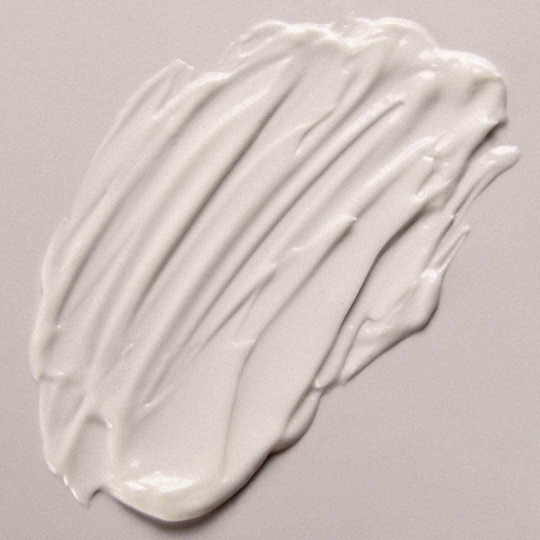 Prodotto bianco su sfondo chiaro. Texture cremosa, applicata a onde. Nessun altro dettaglio visibile.