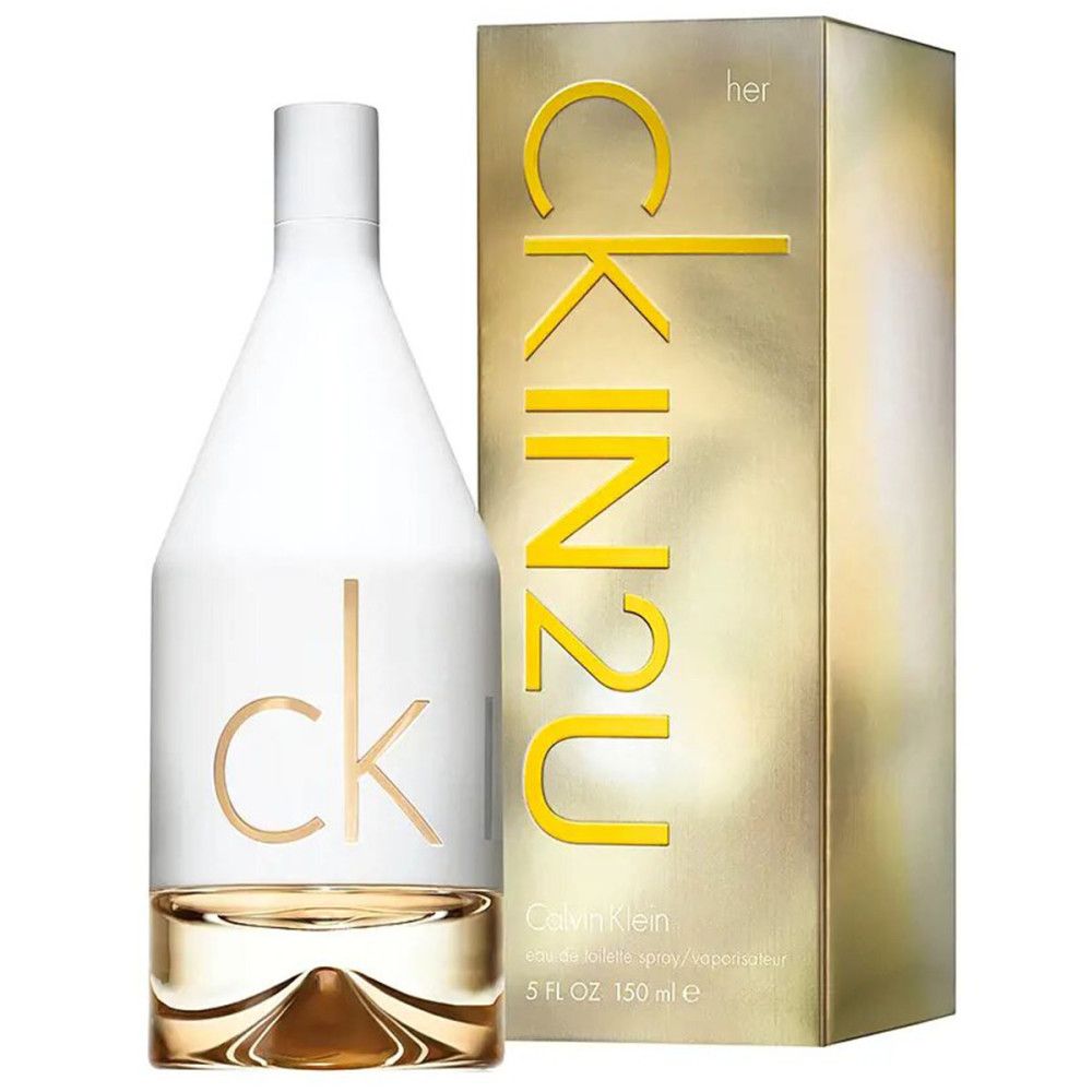 Flacone di profumo accanto a una confezione dorata con scritta 'CK IN2U HER'.
