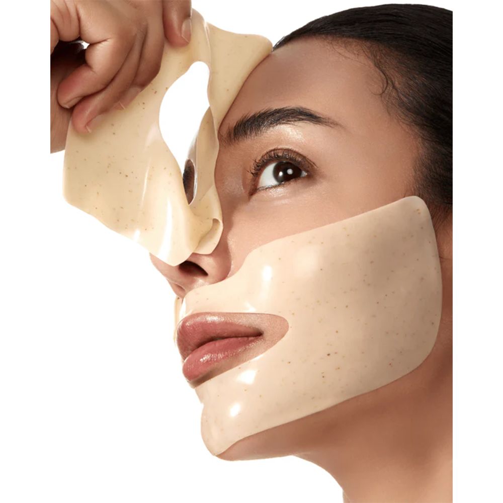 Viso con maschera Anua Rice 70 Glow Collagen applicata. Una maschera viene rimossa. La maschera è beige.