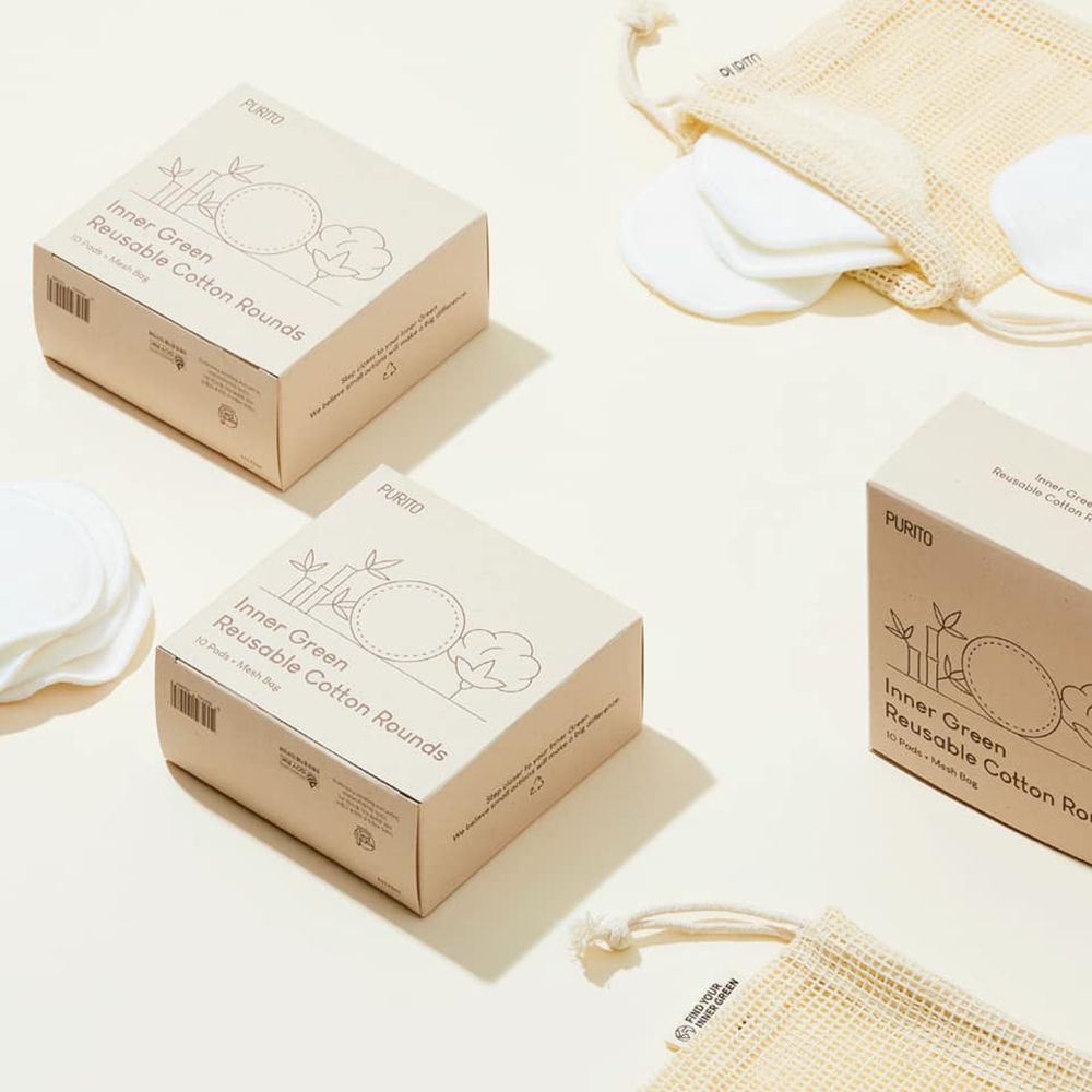 Diverse confezioni del prodotto e dischetti di cotone. Confezioni con testo: PURITO, Inner Green Reusable Cotton Rounds. Dischetti e sacchetti accanto.
