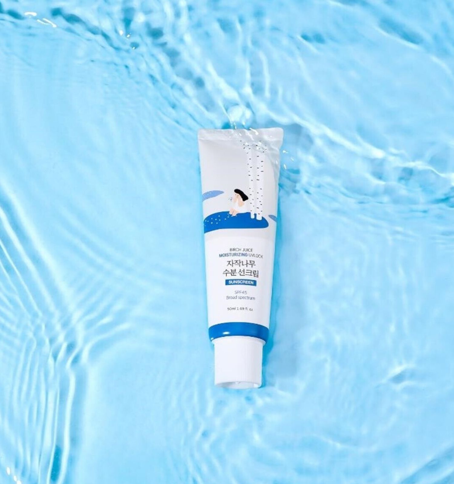 Tubo con motivo di betulla su sfondo blu acquatico. SPF 50+ PA++++.
