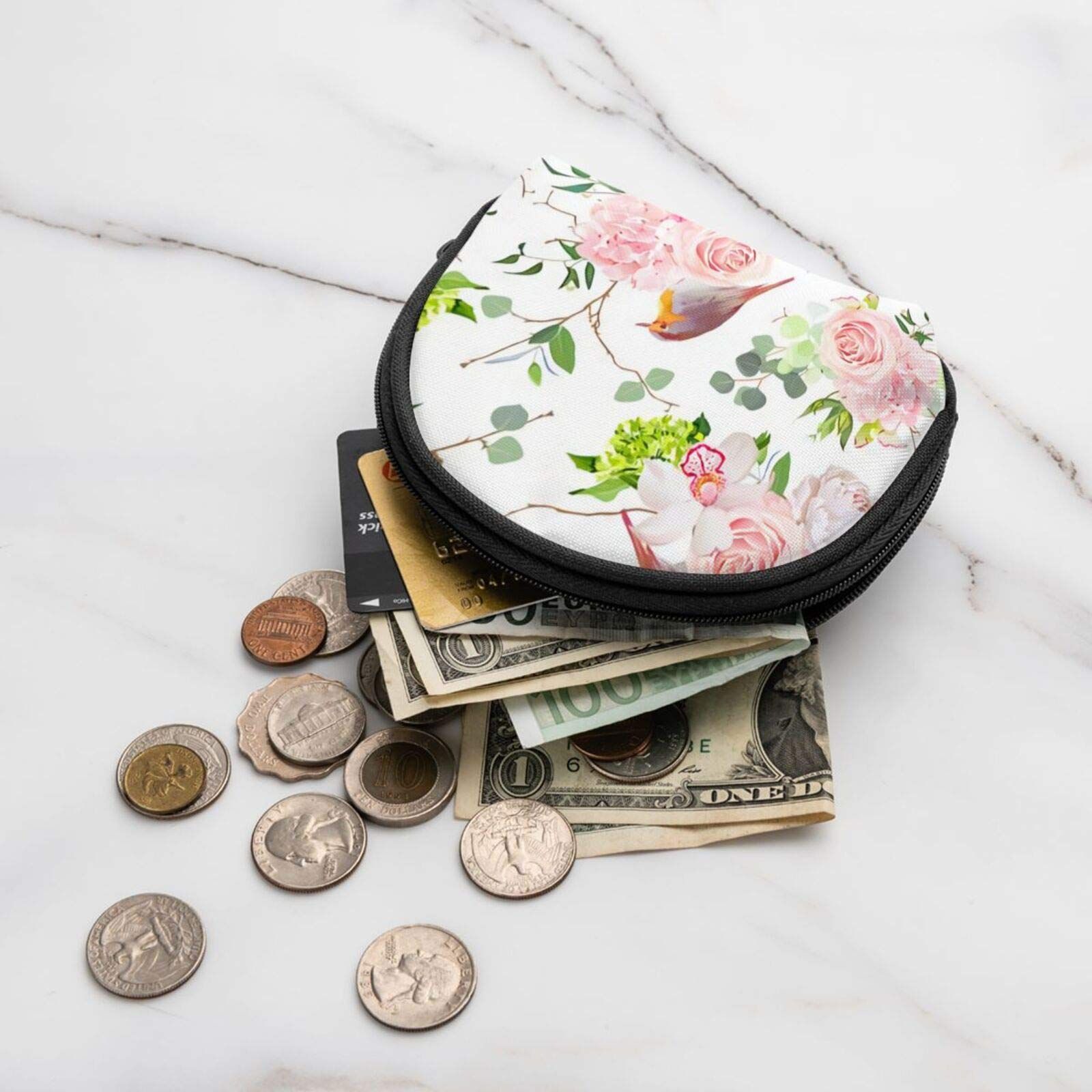 Portafoglio a mezzaluna con motivo floreale e uccello, pieno di soldi e monete. Su superficie marmorea.