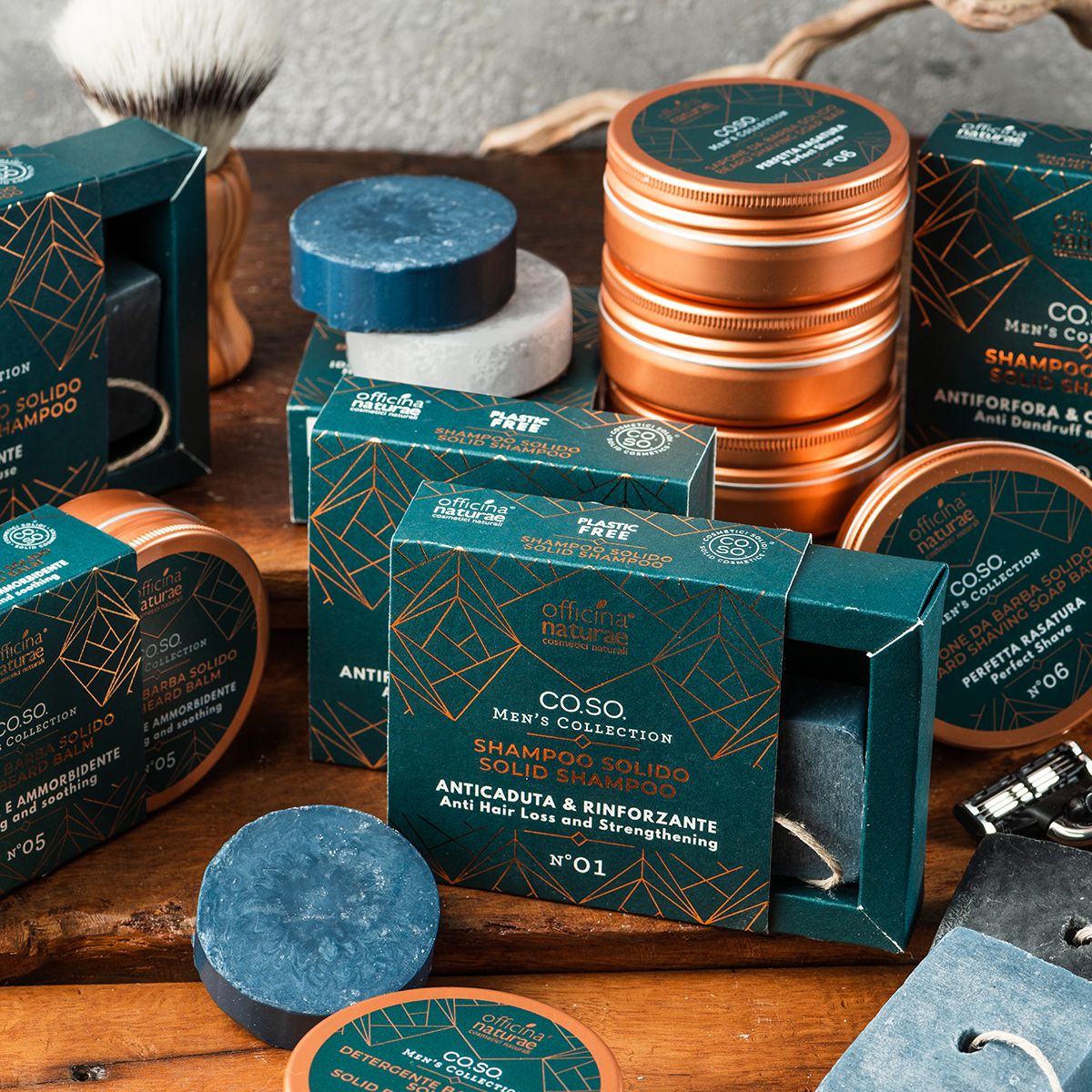 Vari prodotti su legno. Contiene shampoo solidi, barattoli e scatole. Testo: Officina Naturae, Men's Collection, diversi tipi di shampoo.