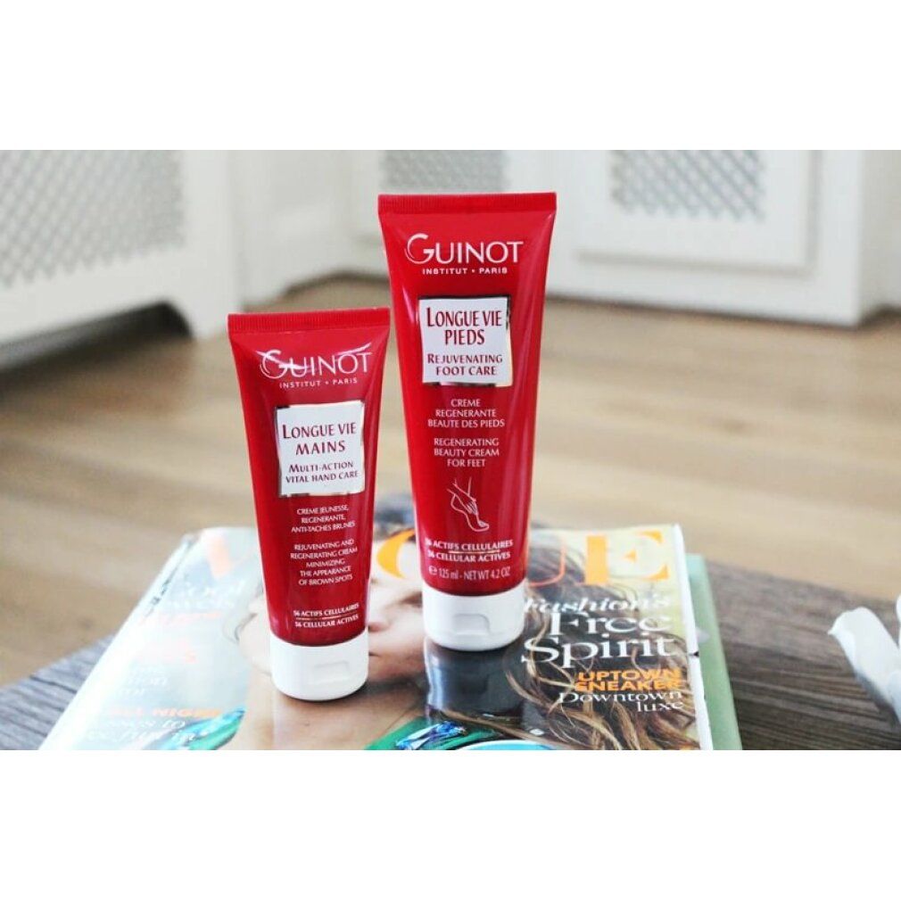 Due tubi rossi Guinot. Uno Longue Vie Mains, l'altro Longue Vie Pieds. Su un libro. Sfondo bianco.
