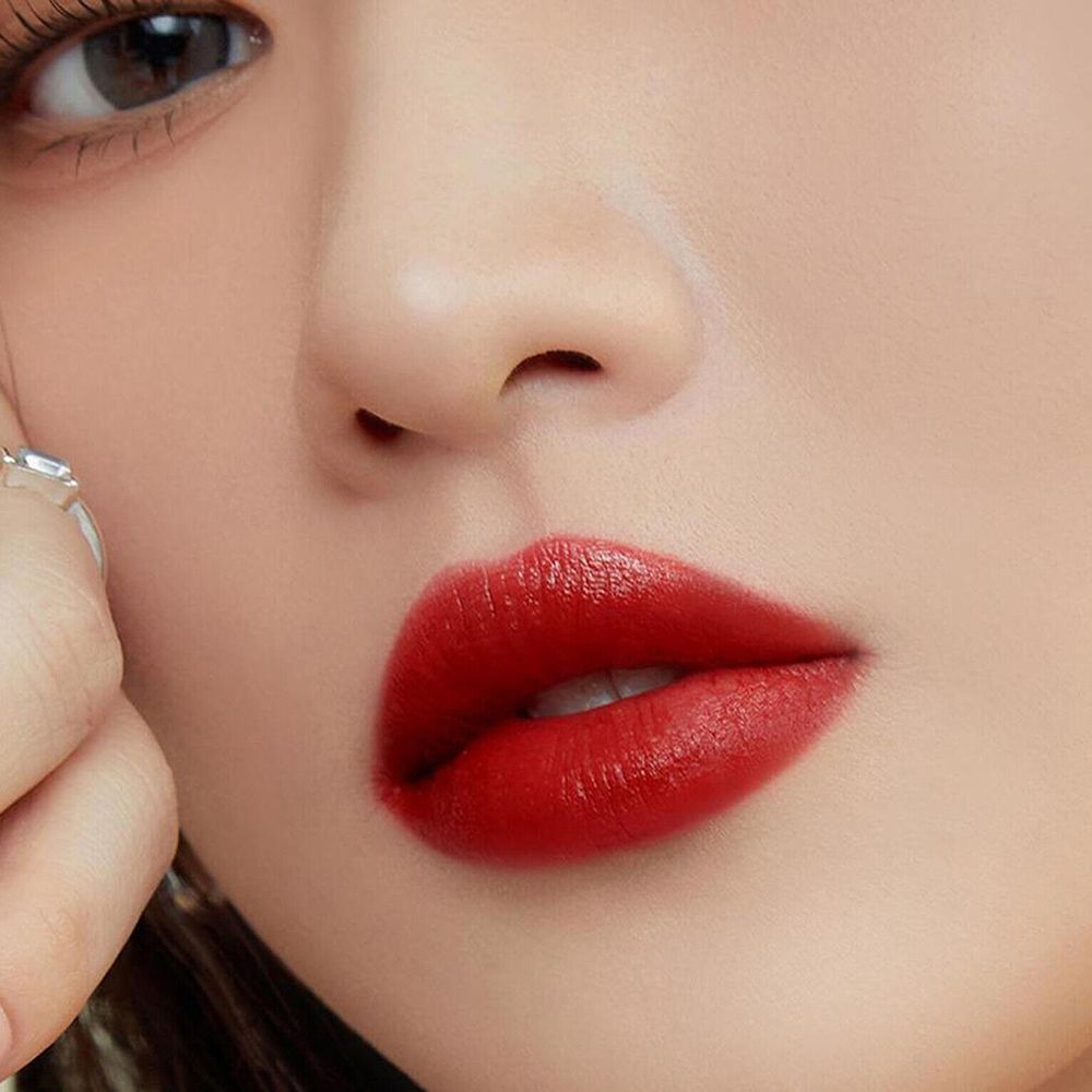 Primo piano di labbra rosse. Le labbra sono coperte di rossetto rosso.