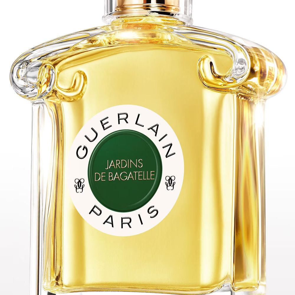 Flacone di profumo con etichetta. Scritta: Guerlain, Jardins de Bagatelle, Paris. Cerchio verde con testo.