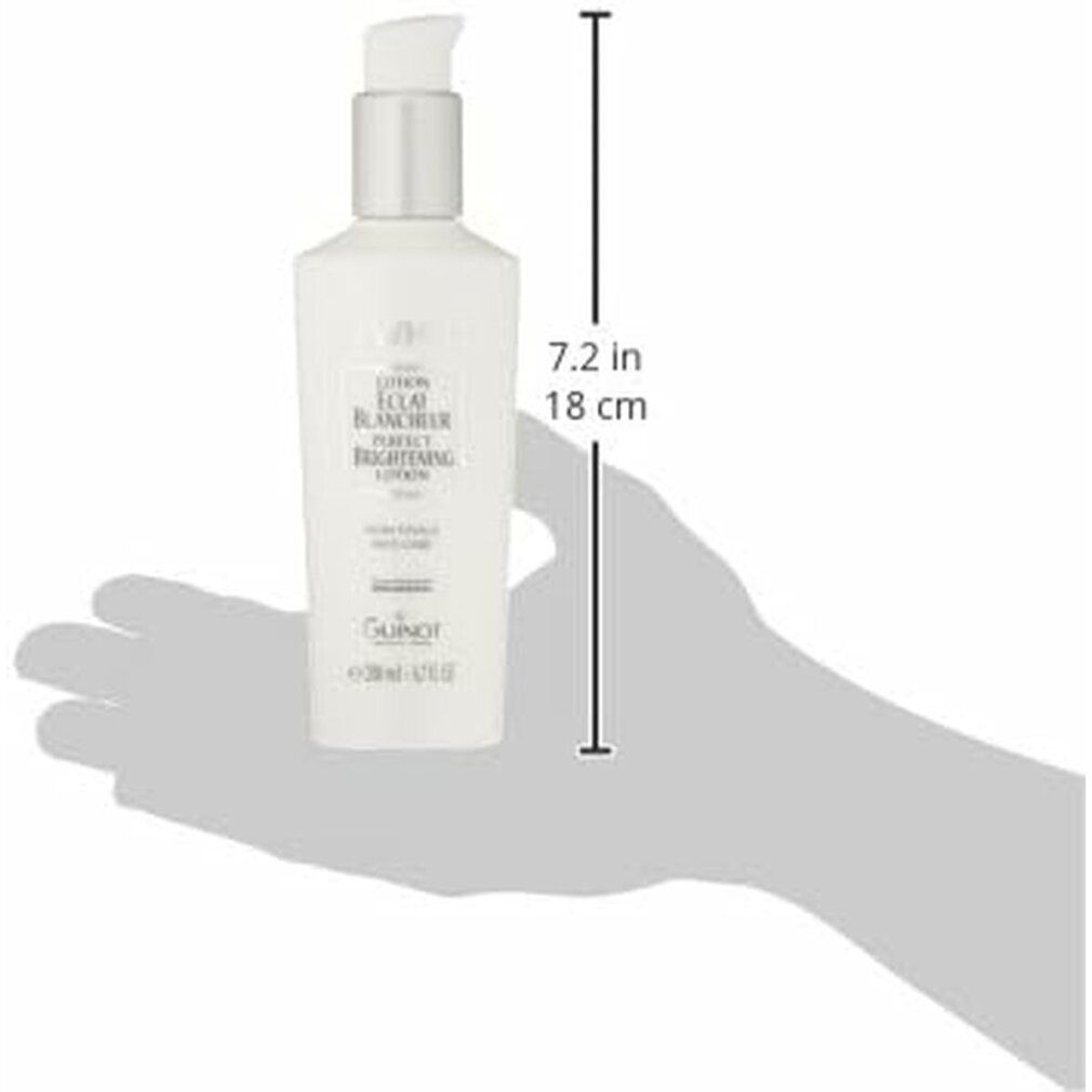 Flacone bianco con dosatore, tenuto da una mano. Scritta NEWWHITE, LOTION ÉCLAT BLANCHEUR. Alto 18 cm.