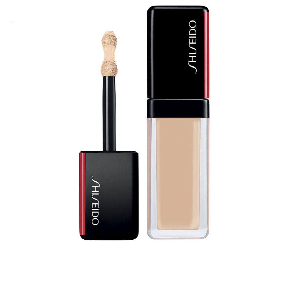 Flacone correttore con applicatore. Tappo nero con dettaglio rosso. Scritta Shiseido. Texture beige chiaro.