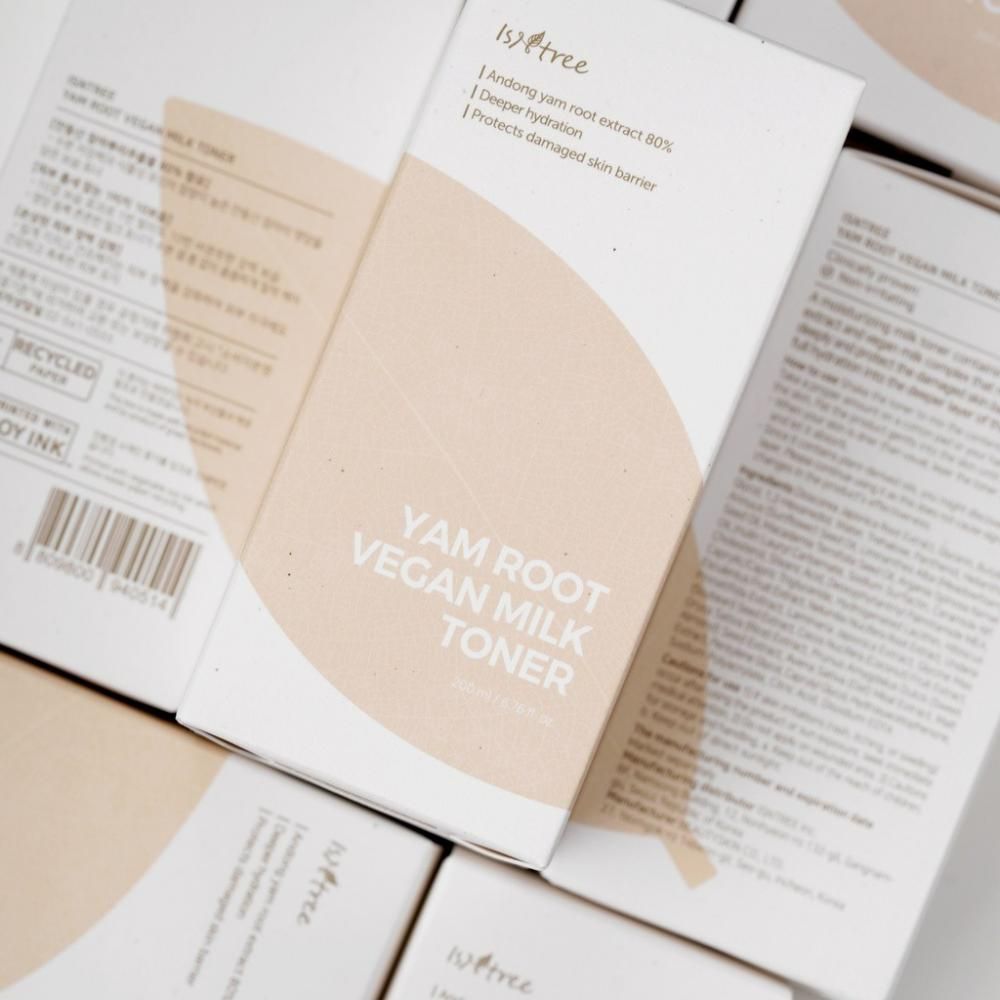 Diverse scatole con informazioni sul prodotto. Scritta: YAM ROOT VEGAN MILK TONER. Stampa beige. Logo di riciclaggio.