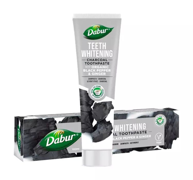 Tubo e scatola di dentifricio Dabur Herbal, sbiancante, con carbone attivo, pepe nero e zenzero.