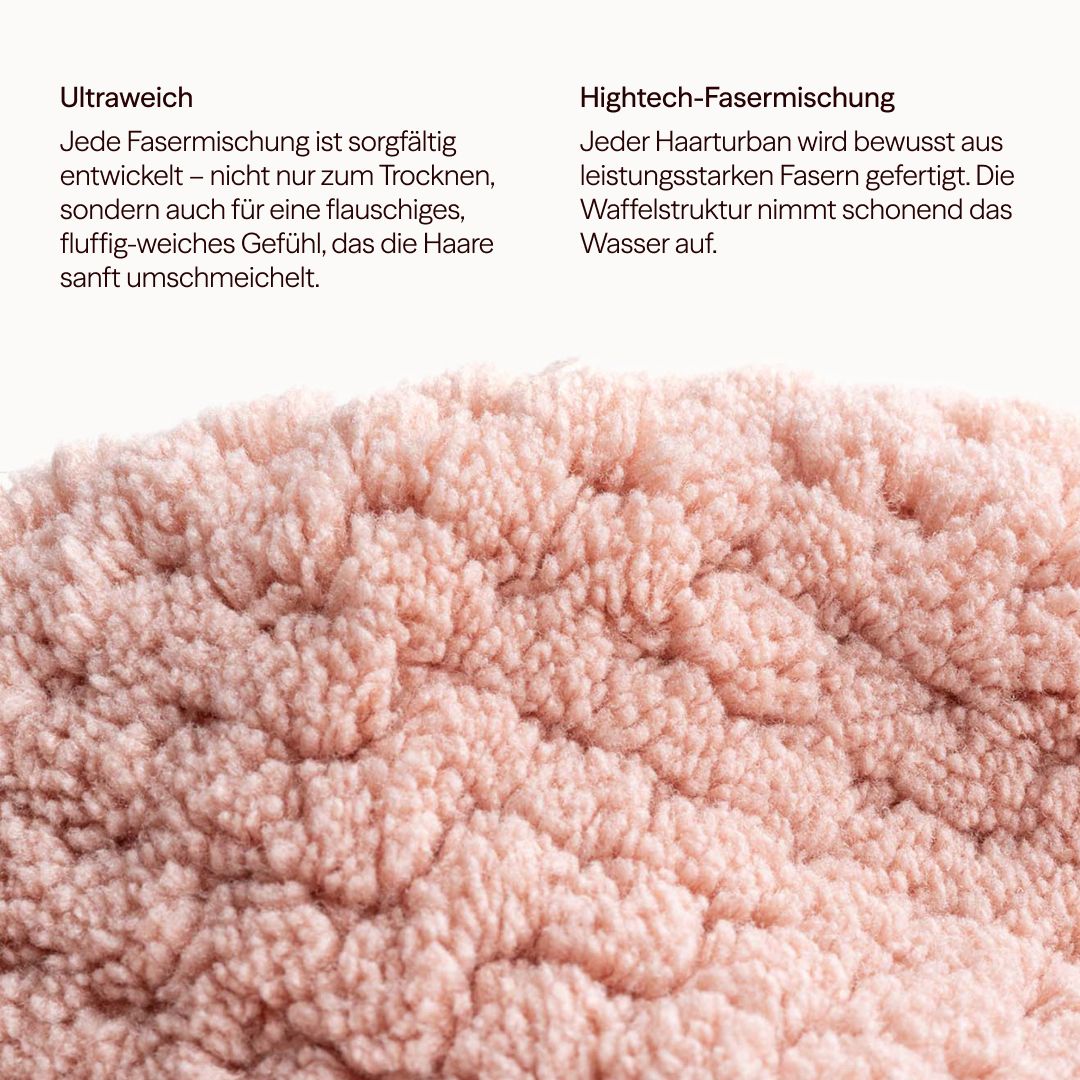 Primo piano di un turbante per capelli rosa con struttura a nido d'ape. Il testo descrive la miscela di fibre ultra morbide e high-tech.