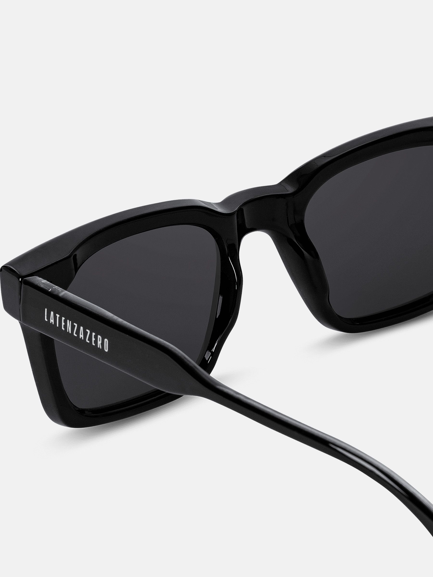 Primo piano di occhiali da sole neri. Scritta LATENZAZERO sulla stanghetta.