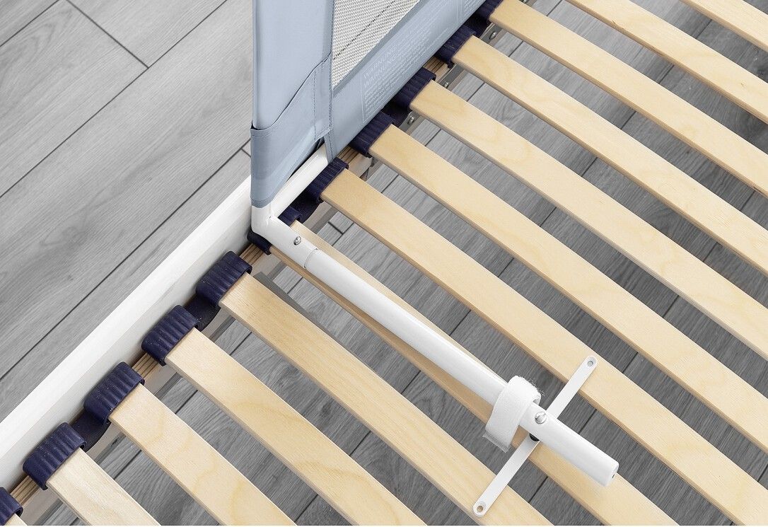 Fissaggio della barriera letto. Struttura bianca, rete a doghe in legno. Staffe metalliche.
