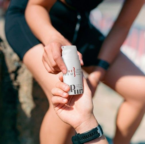Due mani tengono un tubetto bianco di unguento al CBD, testo 'Salbe Warm'.