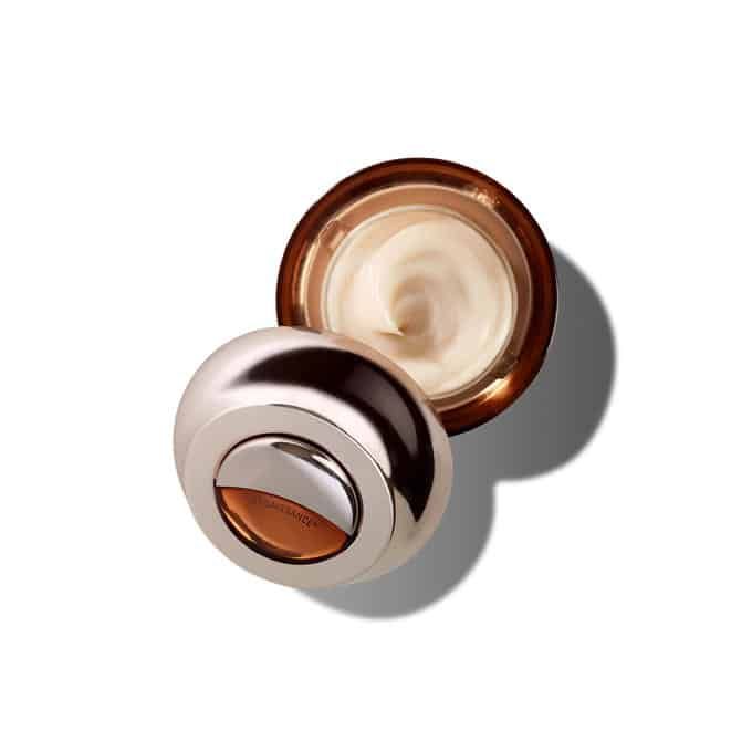 Vaso di crema aperto con coperchio argentato. Crema visibile all'interno. Scritta Genaissance De La Mer.