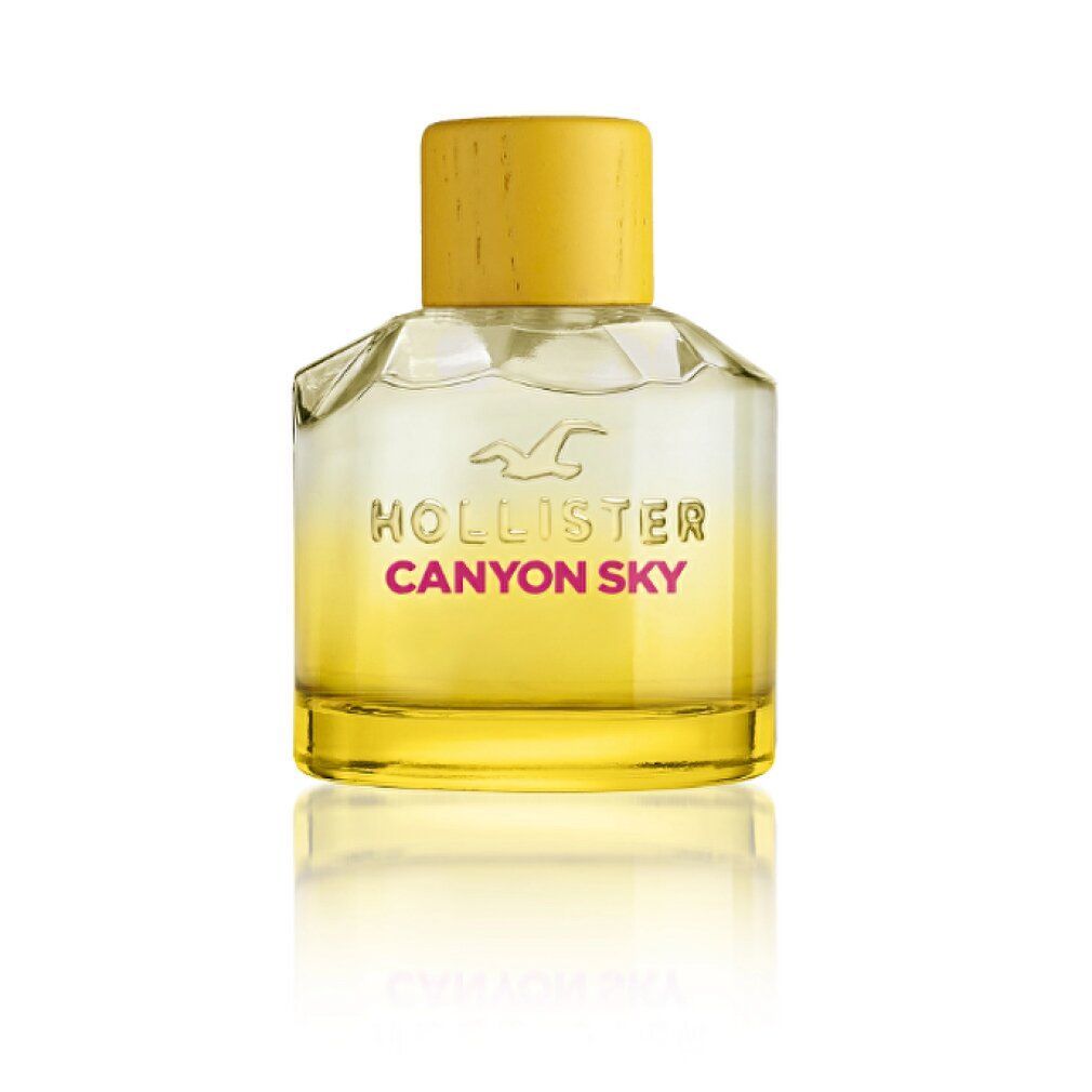 Flacone di profumo con tappo giallo. Flacone in vetro con liquido giallo e scritta Canyon Sky.