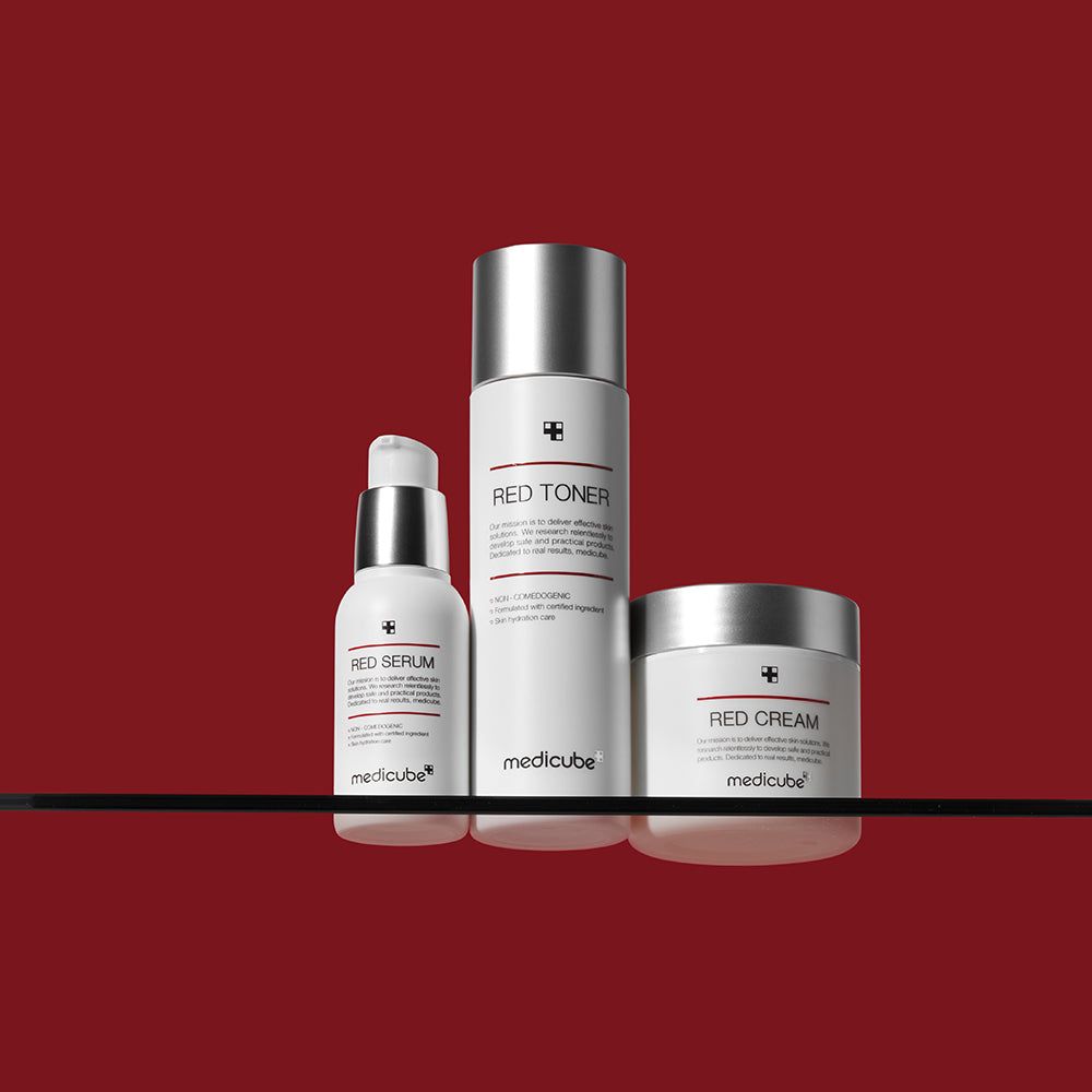 Tre contenitori bianchi, tappi argentati. Scritte: RED SERUM, RED TONER, RED CREAM. Logo: medicube.